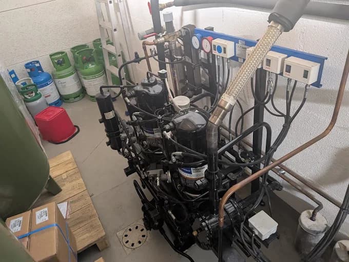 Local technique avec plusieurs compresseurs frigorifiques et bouteilles de fluide réfrigérant lors d'un dépannage de chambre froide