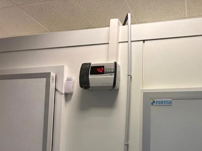 Régulateur de température mural affichant une alarme de dépannage sur une chambre froide