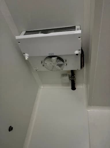 Évaporateur blanc installé au plafond d'une chambre froide neuve, vue d'angle