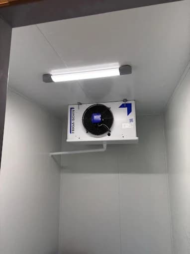 Évaporateur plafonnier blanc avec éclairage LED installé dans une chambre froide positive