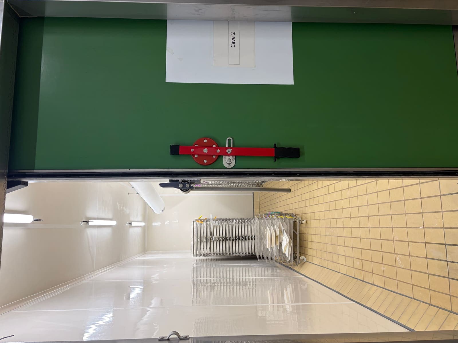 Porte de chambre froide verte ouverte avec joint remplacé, couloir frigorifique avec chariots